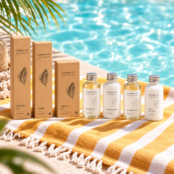 Caribe Kit guest amenities on a yellow and white striped towel beside a swimming pool in Curaçao.